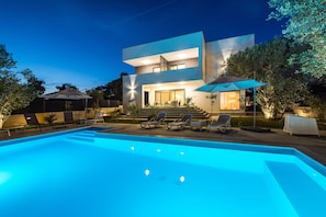 A modern two-story house with a swimming pool, outdoor seating, and a well-lit entrance. - Apartment Vista Mare 2 With Heated Pool (Sveti Filip i Jakov)