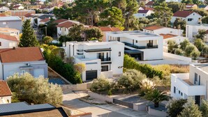 A coastal residential area with modern houses, a clear view of the sea, and a hilly landscape in the background. - Villa Positiva With Heated Pool (Vir)