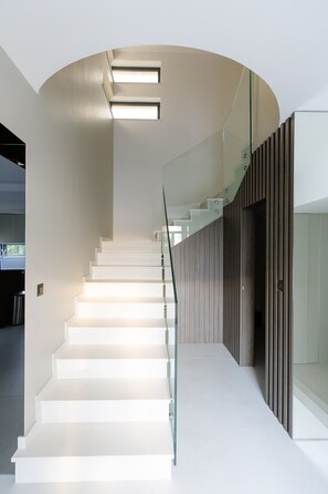 Eine moderne Treppe mit Glasgeländern und integrierter Beleuchtung.