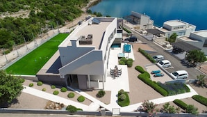 Ein Luftbild eines modernen Hotels mit Dachpool, Außenbereich und angelegtem Garten.