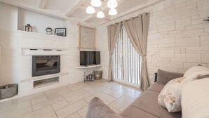 A living room with a fireplace, television, and a sofa. - Villa Edena With Heated Pool (Privlaka)