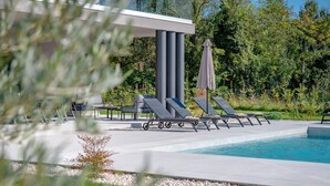 A modern outdoor pool area with lounge chairs and a pergola. - Villa Kalea With Pool (Labin)
