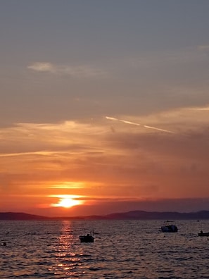 A sunset over a body of water with boats.