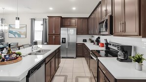 Una cocina moderna con electrodomésticos de acero inoxidable, armarios de madera y una isla grande con fregadero.