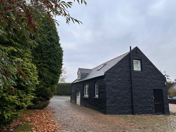 A black stone building with a steep roof, a small window, and a door. - Pets - Garden - Parking - Sleeps up to 4 - Hiking (Banchory)