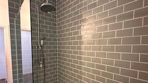 Eine Dusche mit Handbrause und Wandarmatur.
