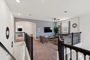 A spacious living area with a TV, seating, and a staircase. - 3 Miles Disney! Closest Resort to Parks!All facilities inc/Private Pool and Spa (Kissimmee)