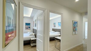 Une chambre d’hôtel avec deux lits, un plancher en bois et des affiches aux murs.
