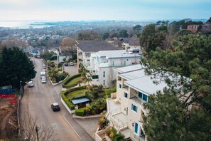 A residential area with modern houses, a curved road, and a distant view of a cityscape.