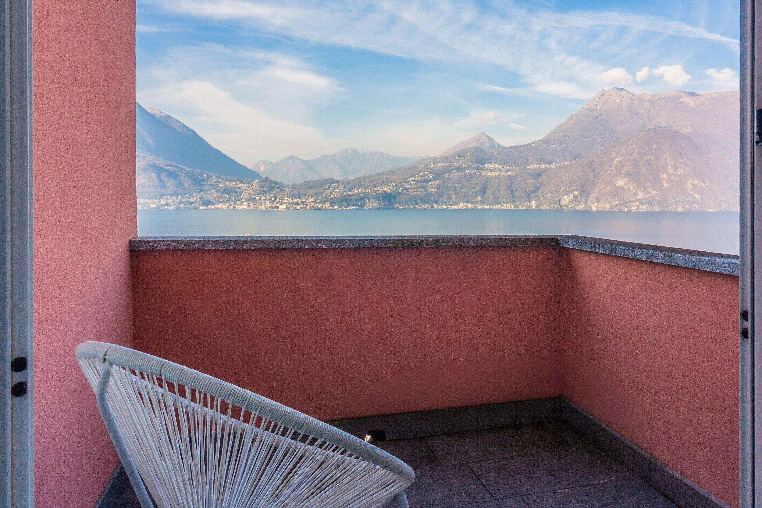 Un balcon avec vue sur un lac et des montagnes.