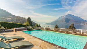 A swimming pool with lounge chairs, a hot tub, and a view of a lake and mountains. - Villa La Perledina in Perledo (Perledo)