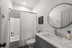 Un bagno moderno con vasca, water e lavabo.