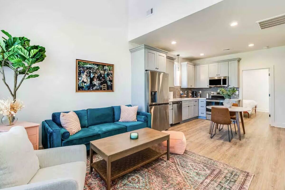 A modern apartment with a living room, dining area, and kitchen.