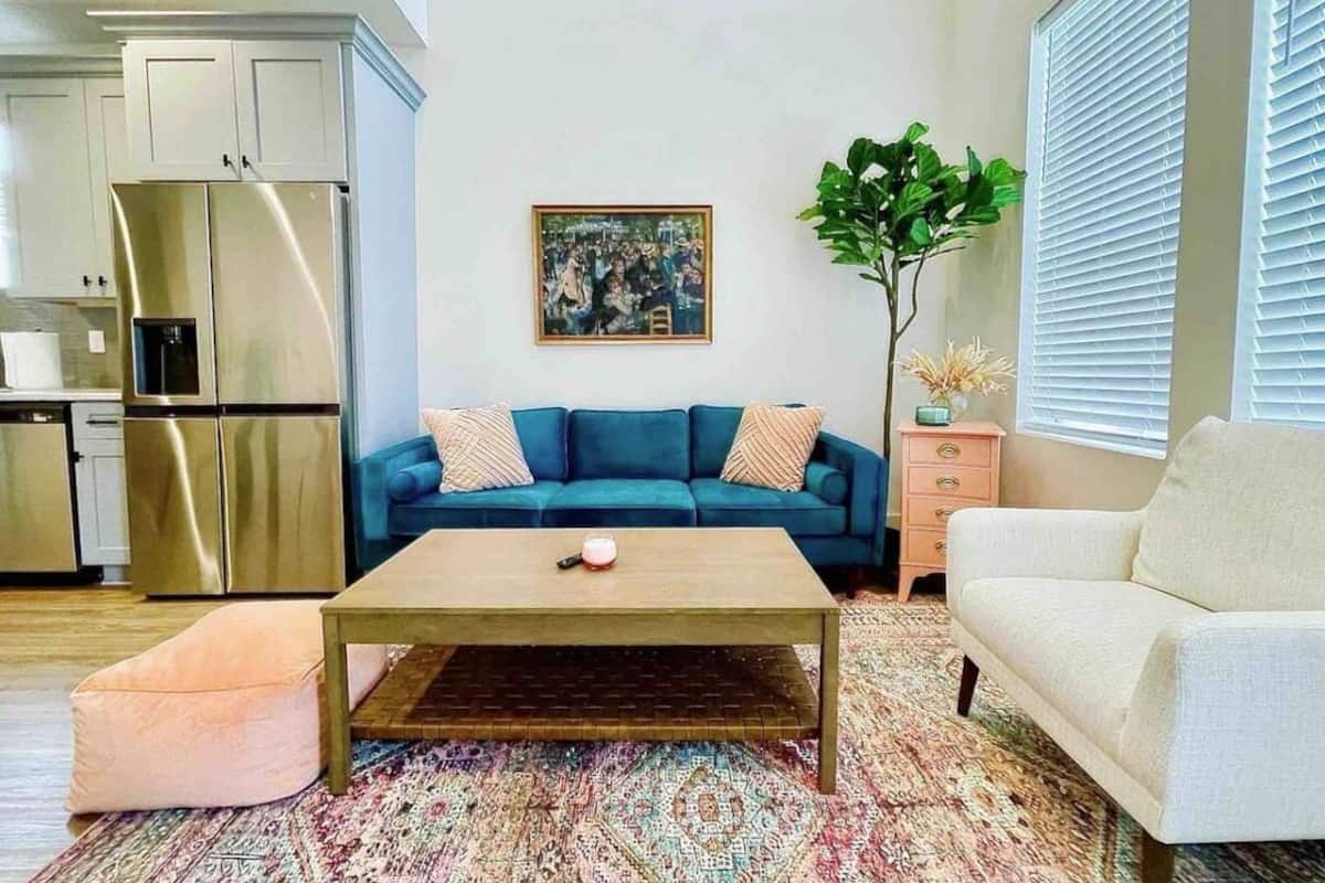 A living room with a sofa, coffee table, and a plant.