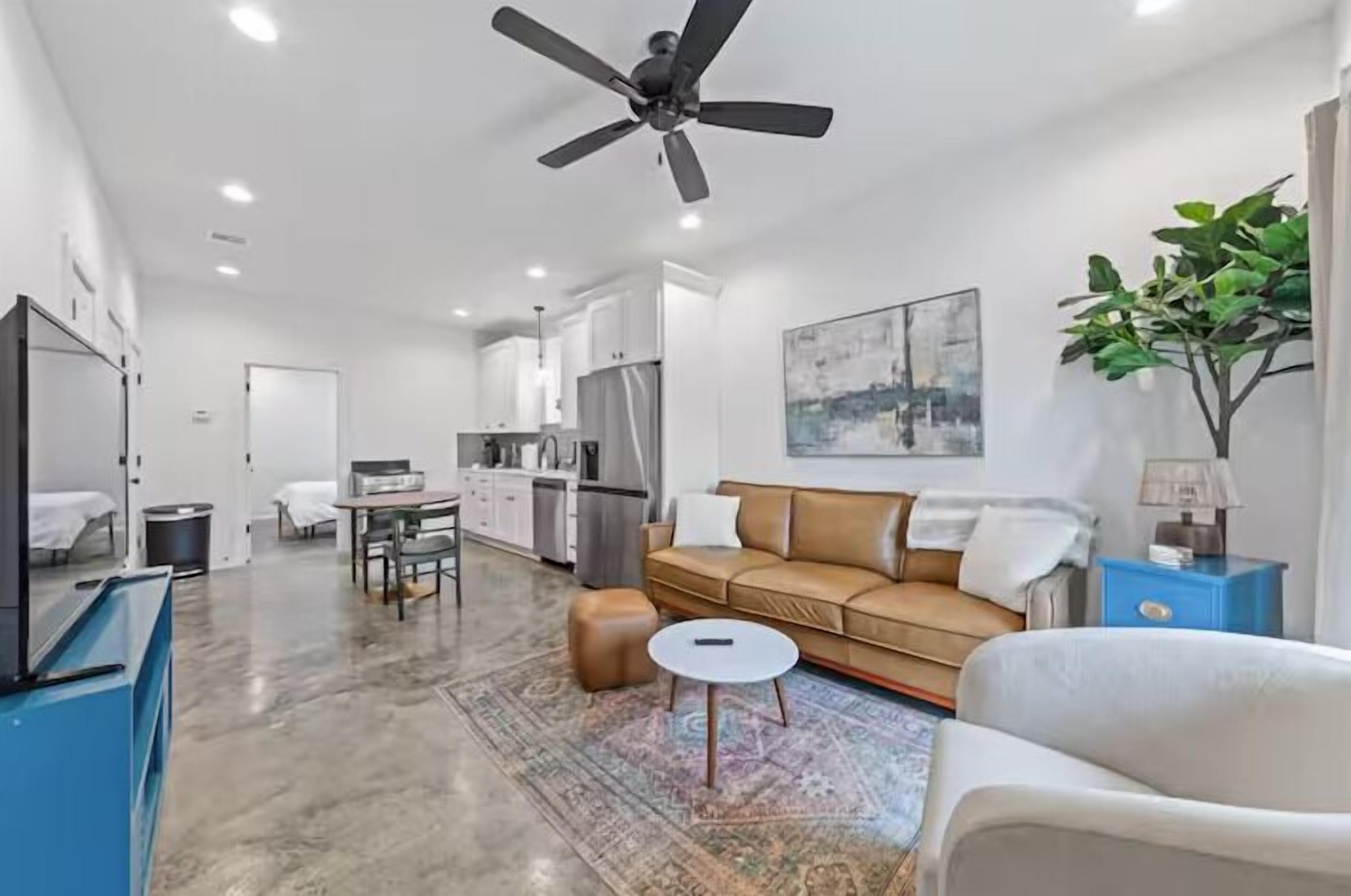 A modern living room with a sofa, coffee table, and a ceiling fan.