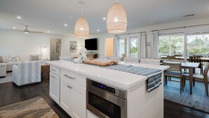 A modern kitchen with white cabinetry, a built-in oven, and pendant lighting. - 22 Sand Dollar - Koi Cottage: Island Serenity, 1st Row, Folly Field (Hilton Head Island)