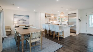 A modern kitchen with white cabinetry, a central island, and pendant lighting. - 22 Sand Dollar - Koi Cottage: Island Serenity, 1st Row, Folly Field (Hilton Head Island)