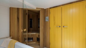 Quarto com guarda-roupa de madeira, banheira branca e armário de madeira.