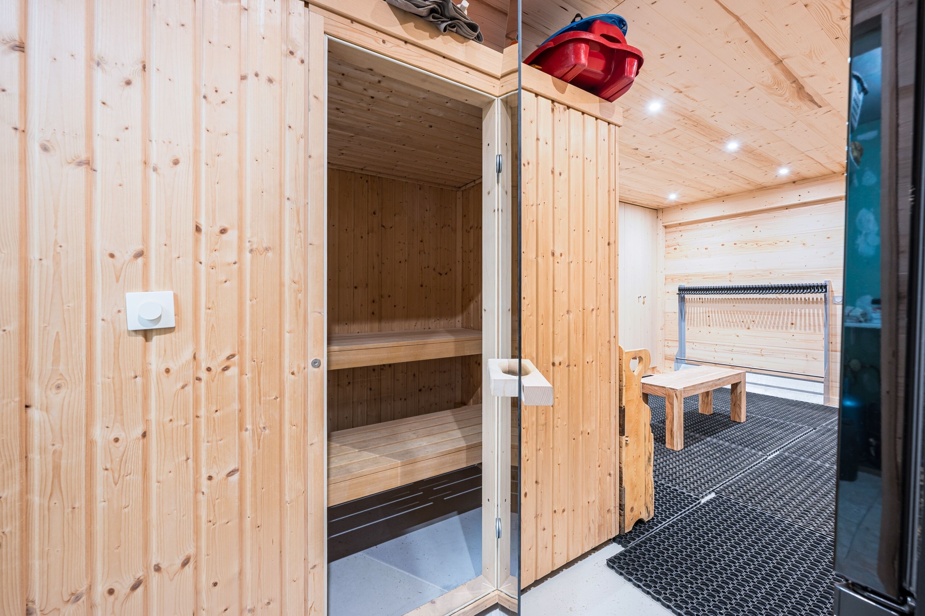 A sauna room with wooden walls and a bench.