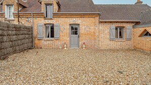 A brick house with a gravel driveway, a wooden fence, and a small garden area. - Coeur de Sologne - Proximité Châteaux de la Loire (Saint-Viâtre)