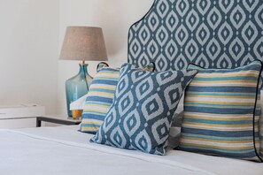 A neatly made bed with patterned pillows and a matching headboard. - Terra Di Corfu, Αpartment (Kerkira)