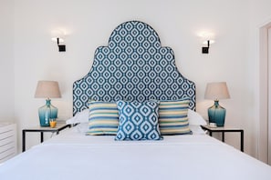 A hotel room with a large bed, two bedside tables with lamps, and a patterned headboard. - Terra Di Corfu - Panoramic Penthouse, Αpartment (Kerkira)