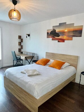A bedroom with a wooden bed, a desk, and a chair. There is a painting on the wall and a hanging light fixture. - Le clos de Précy- House 132 m² 10 pers Private garden Quiet 20 min Disneyland (Précy-sur-Marne)