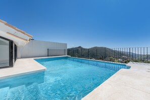 A swimming pool with a clear view of mountains in the background.