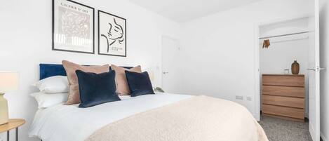 Tabla de planchar con plancha, internet y ropa de cama