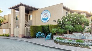 Dolphin's Cove Rescue building with a logo, a gated entrance, a staircase, and decorative sculptures.