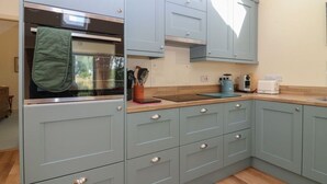 A kitchen with light blue cabinets, a stainless steel oven, and a wooden countertop. - The Barn, Romantic Countryside Escape near St Andrews (Cupar)