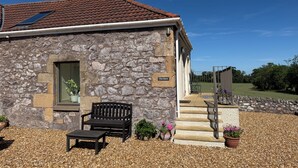 A stone building with a tiled roof, a bench, and potted plants. - The Barn, Romantic Countryside Escape near St Andrews (Cupar)