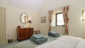 A bedroom with a bed, a dresser, a mirror, and a window with curtains. - The Barn, Romantic Countryside Escape near St Andrews (Cupar)