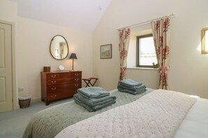 A bedroom with a bed, a dresser, a mirror, and a window with curtains. - The Barn, Romantic Countryside Escape near St Andrews (Cupar)