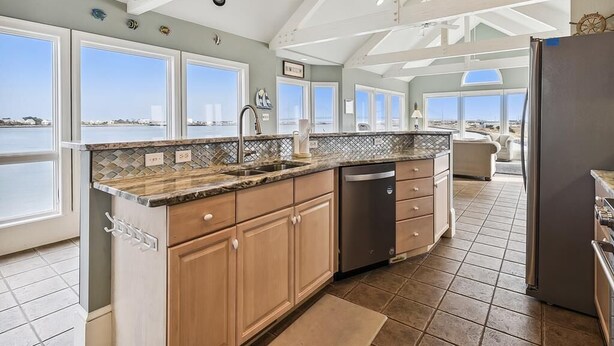 A kitchen with a view of the sea, a dishwasher, and a refrigerator. - Spacious Beach House | Decks & Pool + Beach Nearby (Bethany Beach)