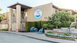 Dolphin's Cove Rescue building with a logo, a gated entrance, a staircase, and decorative sculptures. - Anaheim | Romantic Disney Retreat | Pool + Parks (Anaheim)