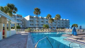 A hotel with a swimming pool, palm trees, and a clear blue sky. - Sunset Cove – Tampa Sunsets from Your Balcony (Tampa)