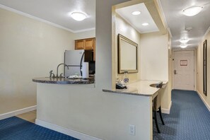 Cocina compacta con refrigerador, pileta y encimera.