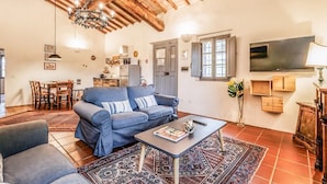 A living room with a sofa, coffee table, and a TV. - Tenuta della Selva - Castellaccio 7 (Murlo)