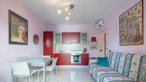 Un espacio habitable pequeño con kitchenette, comedor y sofá.