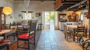 A rustic interior with a bed, wooden furniture, a dining area, and a kitchen. - Tsoupis Villa (Kentroma)