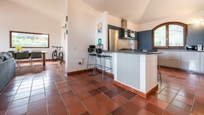 Una cucina moderna con isola centrale, zona pranzo con bicicletta e un'ampia finestra che offre luce naturale.