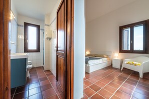 A bedroom with a bed, bedside table, and a window. - Villa Ulivi 10 – Is Molas Golf Resort (Is Molas)