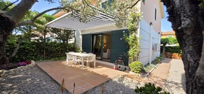 A patio with a table and chairs, a barbecue grill, and a covered area with a pergola. - Daró 3D 03 Corner house with air conditioning, pool, close to the beach (Torroella de Montgri)