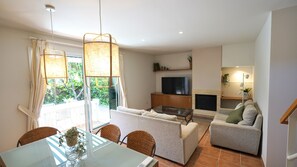 A modern living room with a sofa, a TV, and a fireplace. - Daró 3D 03 Corner house with air conditioning, pool, close to the beach (Torroella de Montgri)