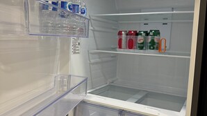 An open refrigerator with clear shelves, containing water bottles and cans of Canada Dry ginger ale. - Slice Of Paradise! 2 bdrm suite close to Stoney Trail, YYC airport & Banff. (Calgary)