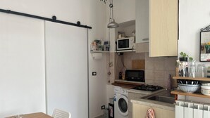 Een koffiezetapparaat/waterkoker, een koelkast, een oven, een kookplaat