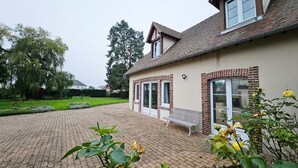 Ein Gebäude mit Backsteinfassade, großen Fenstern und einem gepflasterten Innenhof.