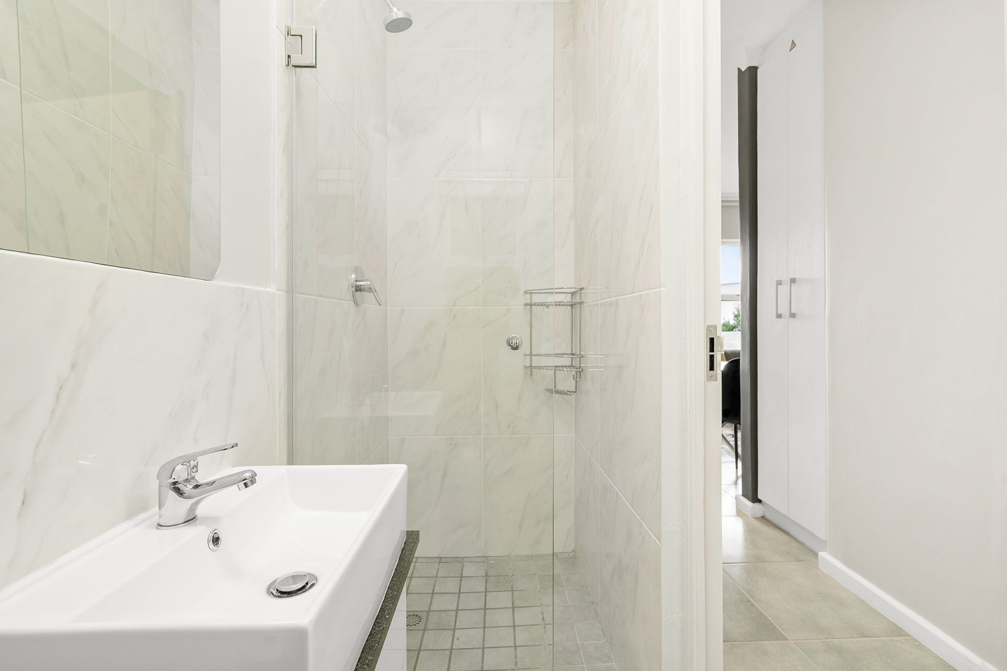 Een moderne badkamer met een witte badkuip, een douche en een douchecabine met glazen wanden.