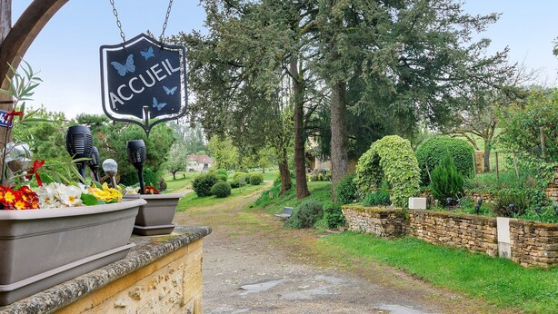 A garden entrance with a sign reading 'ACCUEL,' potted plants, and a stone wall. - Cottage for 2 with Heated Pool and Wi-Fi in Quiet Sarlat Setting (Sarlat-la-Canéda)